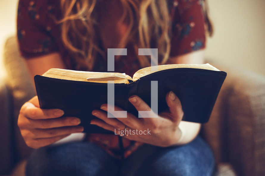 a woman sitting reading a Bible 