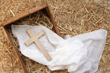 cross and manger in hay 