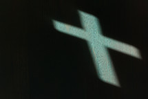 shadow of a cross on teal wood 