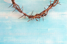 crown of thorns on teal wood background 