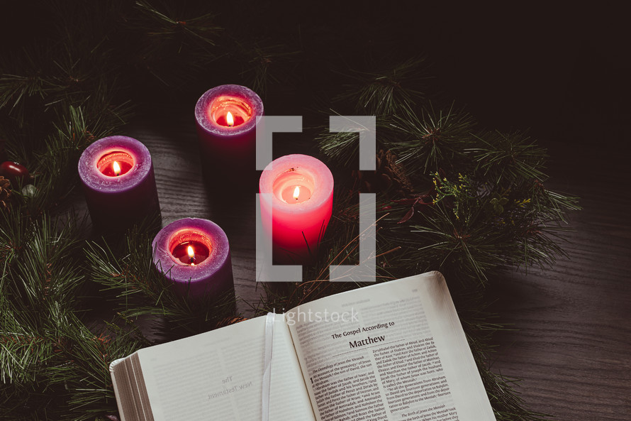 Open bible with an advent wreath on a dark wood table
