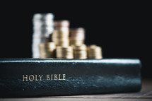 Coins on top of a Bible