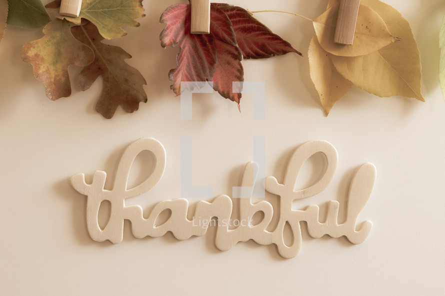 Fall leaves on clothespins and wooden word thankful