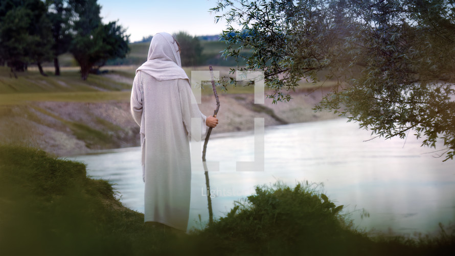 Jesus Christ prays alone by the river Jordan. 
