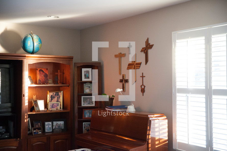 wooden crosses above a piano in a home 