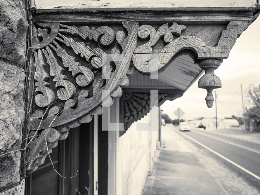 weathered gingerbread trim in black and white with soft-focus small town street