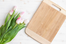 pink tulips and a cutting board 