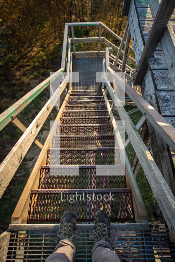 Shoes of explorer going down wood and metal watchtower steps in Bickle Knob West Virginia