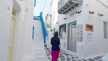 Female tourist exploring and walking in the streets of Chora, Mykonos, Greece.
