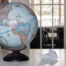 globe and paper airplane on a table 