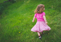 a little girl running in grass