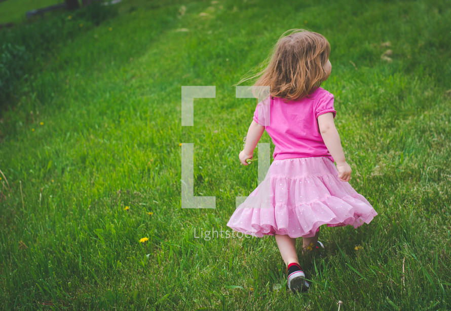 a little girl running in grass