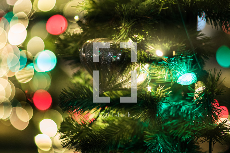 ornament on a Christmas tree and bokeh Christmas lights 
