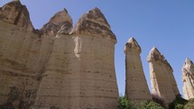 Fairy chimneys. Cave houses carved into hoodoo mountain above Rose Valley and Cappadocia nature landscape in Goreme, Turkey.
