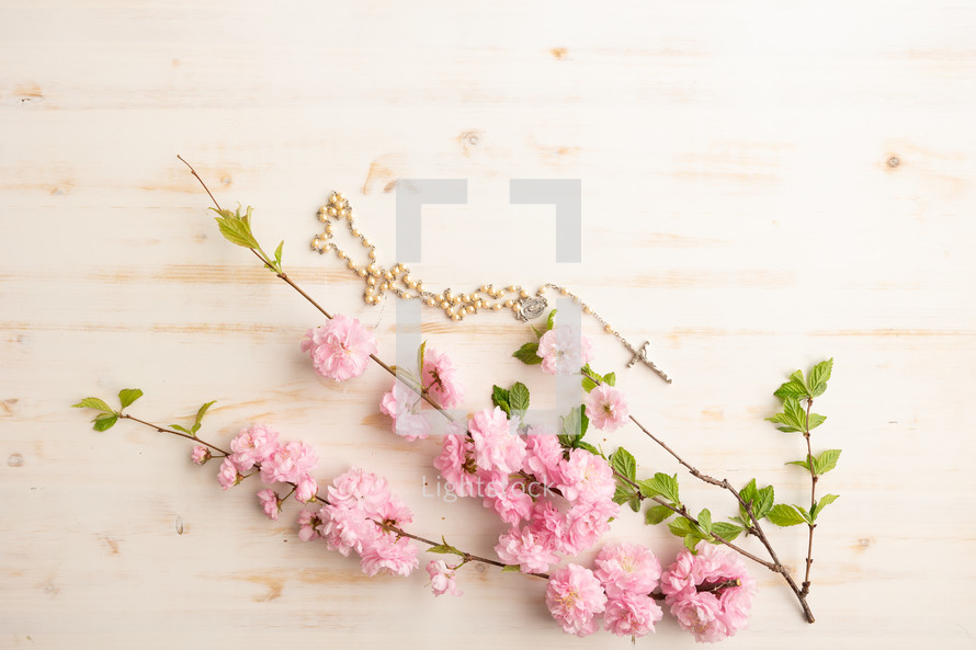 Rosary with pink flowers on a white background