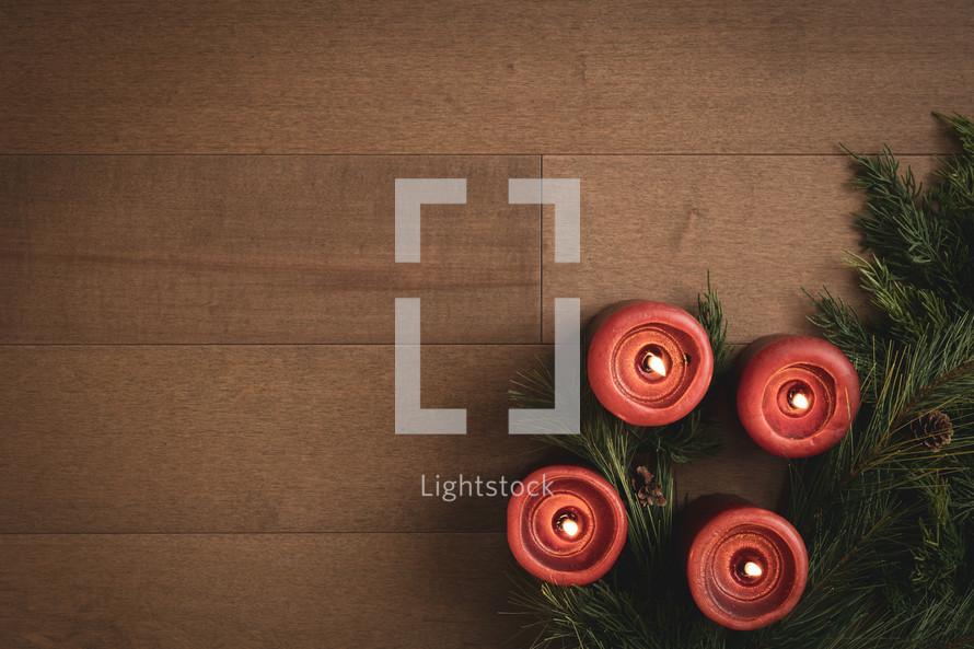 Red candles on wood with garland