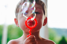 a boy blowing bubbles 