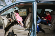 kids in a mini van ready for a road trip 