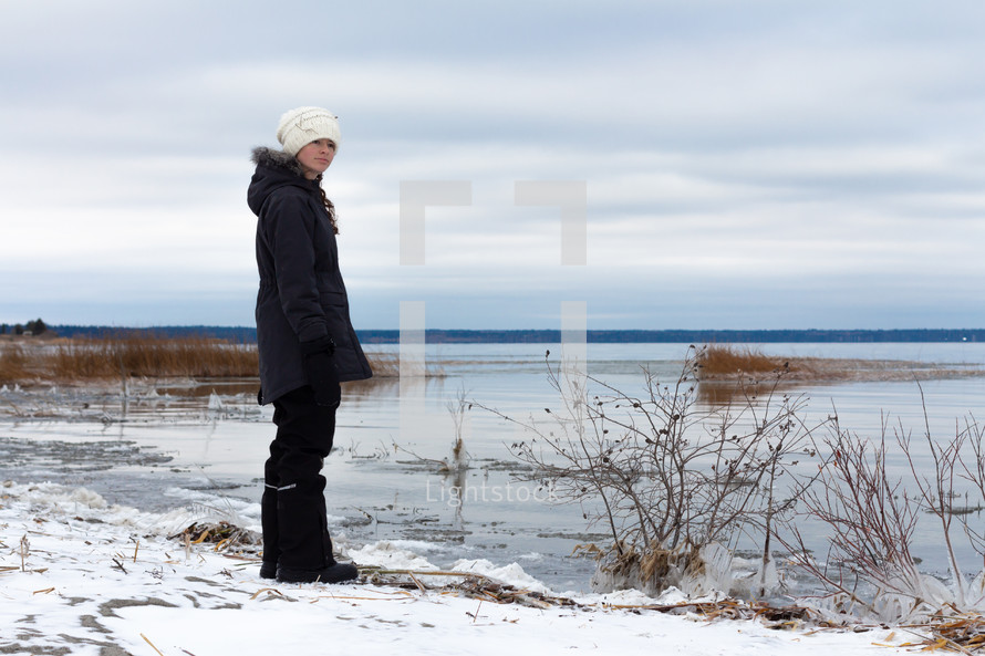 a teen girl looking out at a frozen lake 