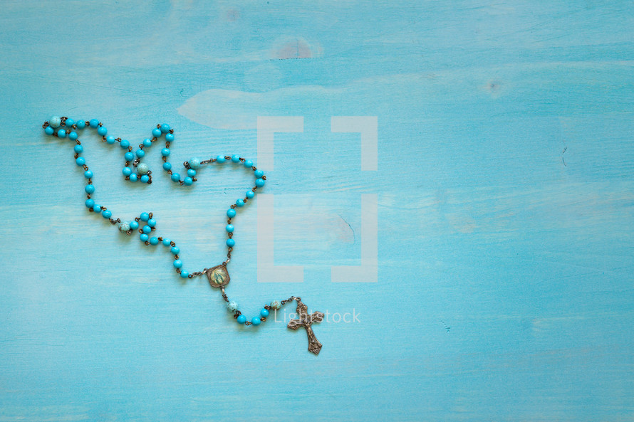 rosary on a blue wood background 