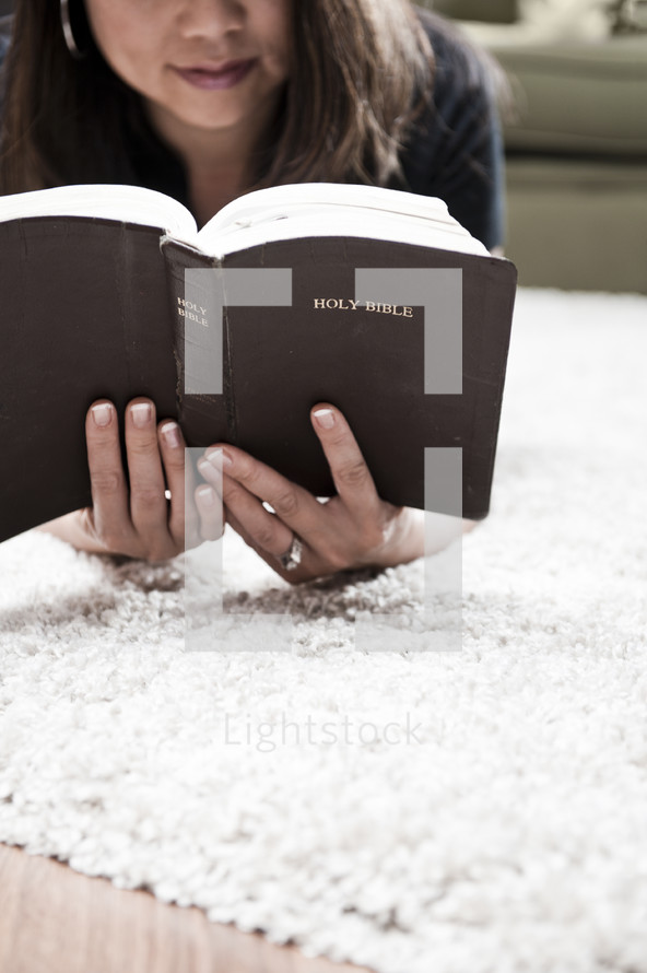 woman reading a Bible lying down 