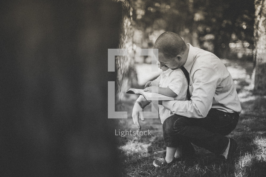 father reading a Bible with his son