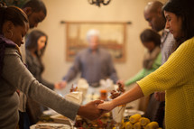 family holding hands in prayer at a dinner table 