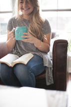 woman drinking coffee and reading a Bible in her lap 