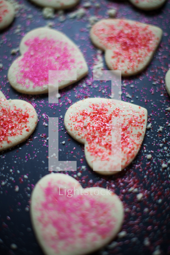 pink and red sprinkles on heart shaped cookies 