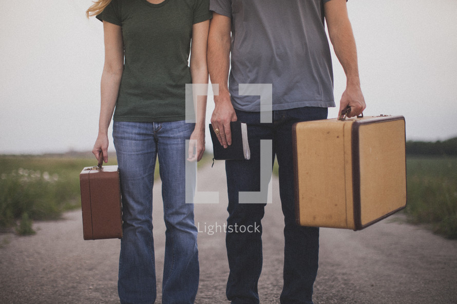 man and woman carrying suitcases and holding a Bible