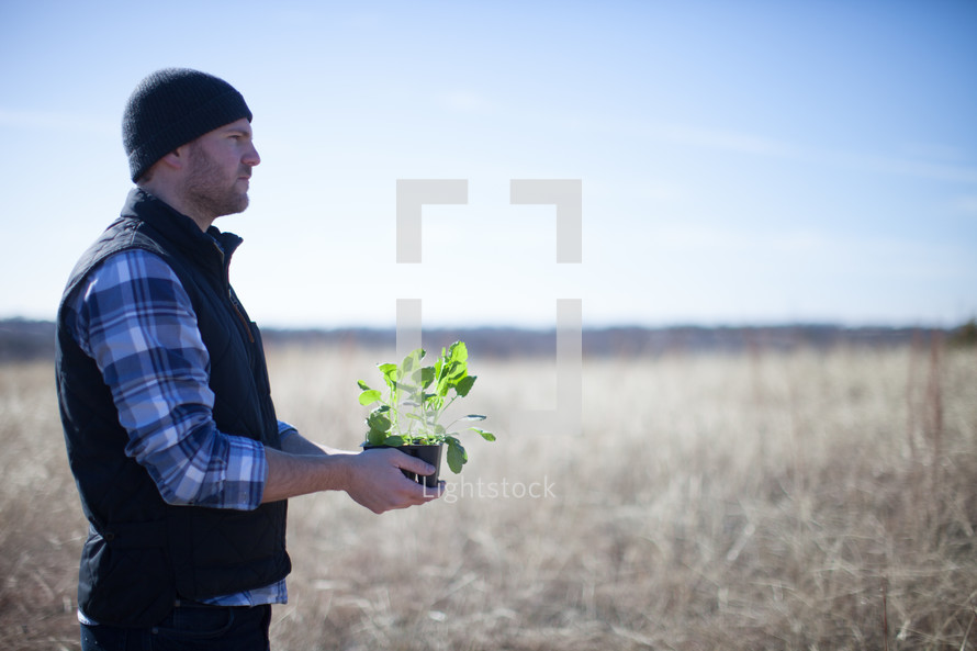 man holding a plant to be planted 