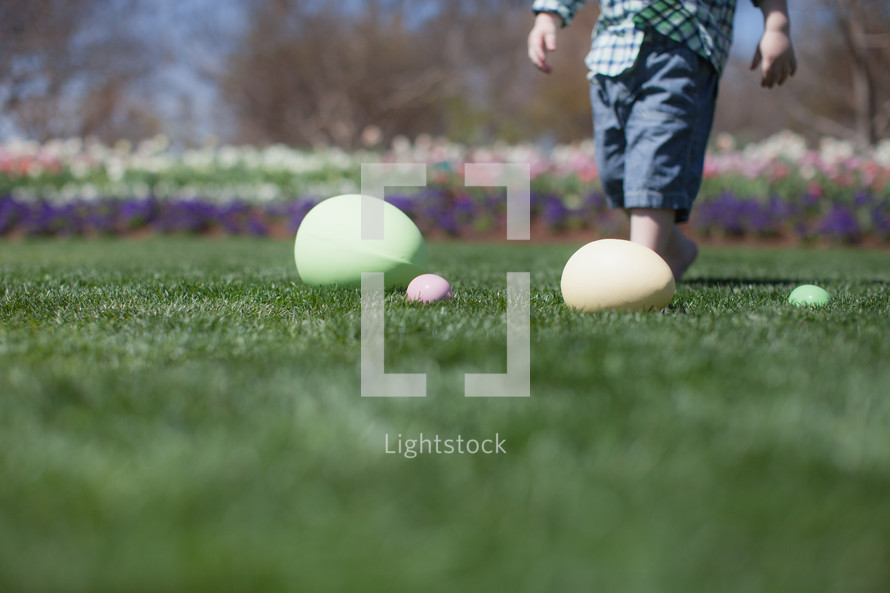 Young boy gathering Easter eggs in a flower garden