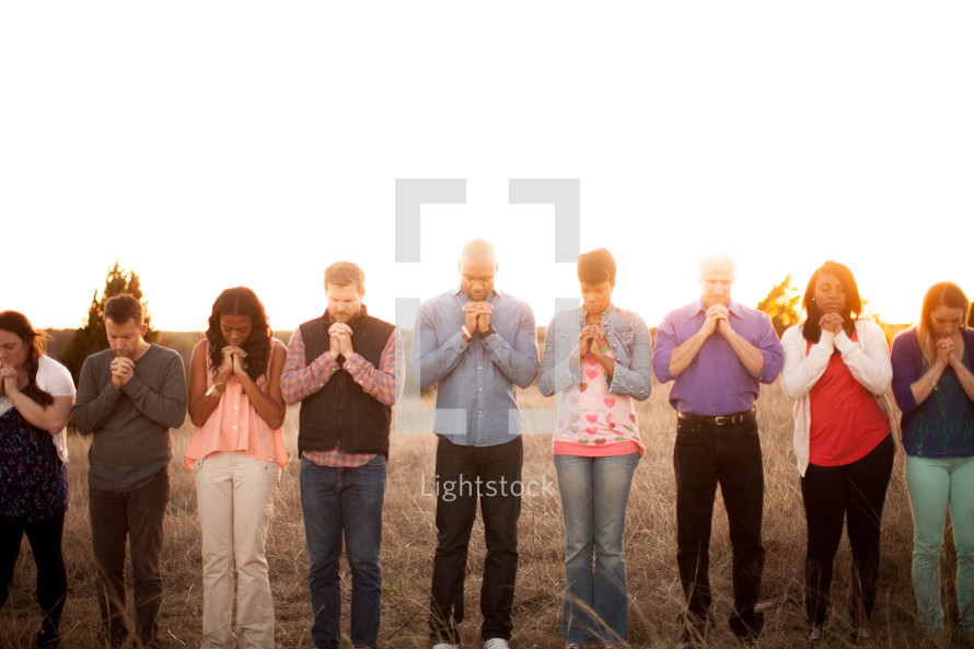 group, prayer, praying hands, heads bowed, man, woman, African American, outdoors 