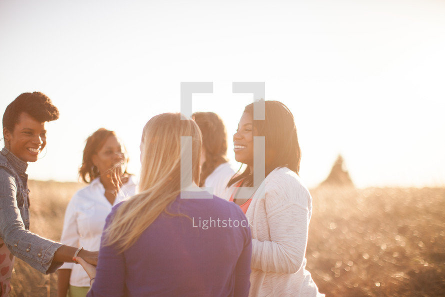 women standing outdoors in a field under intense sunlight 