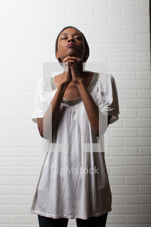African-American woman with praying hands looking to God 