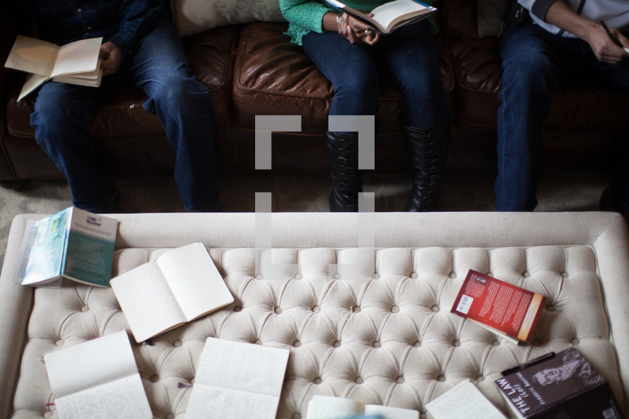 Bibles, journals, and books on a coffee table at a Bible study 