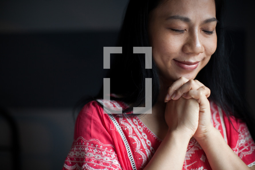 Asian woman with praying hands 