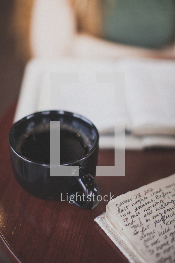 Coffee cup on a table with a Bible and notes.