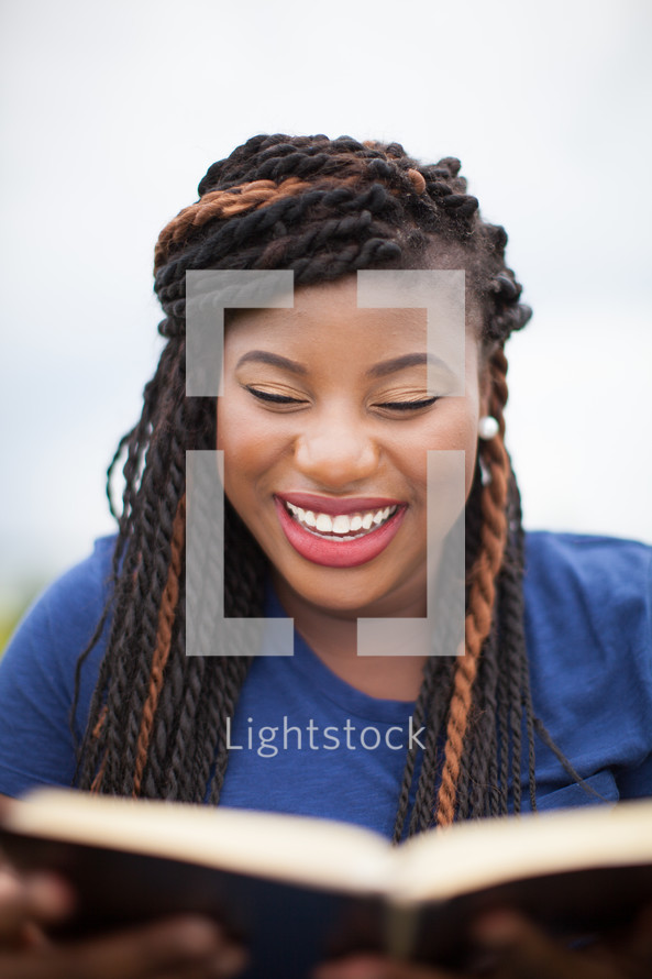 smiling African-American woman reading a Bible 