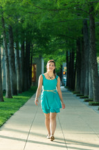 a man in a blue dress walking down a sidewalk 