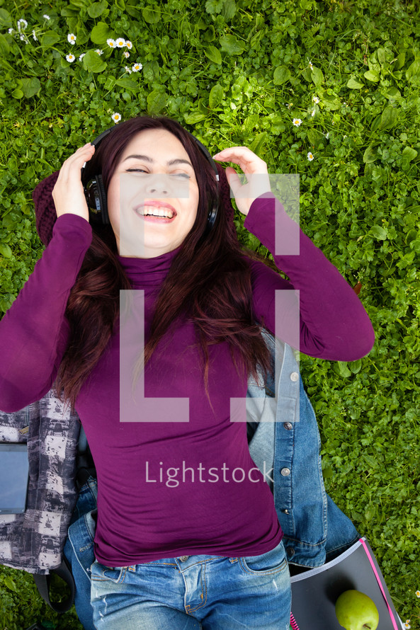 young woman listening to headphones outdoors 