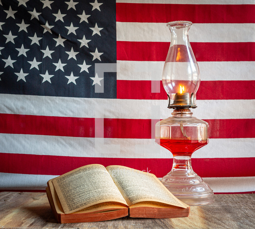Open Holy Bible and old fashioned oil lamp with American flag background square