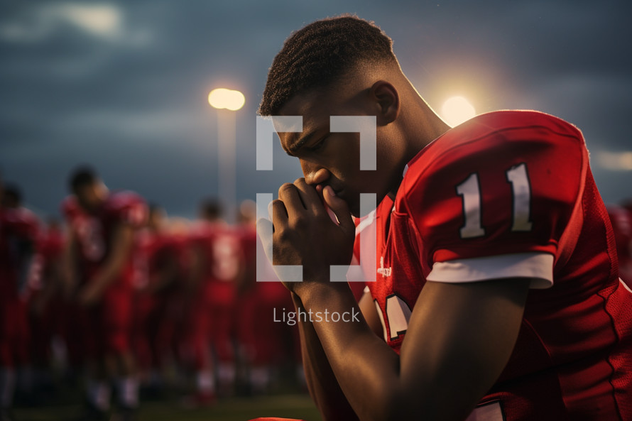 Football player praying before a game