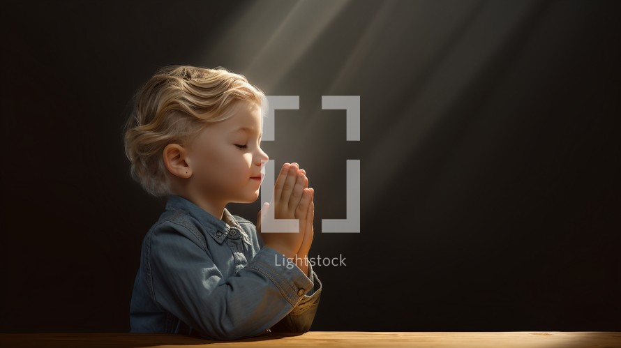 Child praying on black background