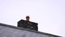 Chimney Cleaning Brush Coming Out of a Chimney Pot and Going Back in Again