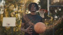 Portrait of a smiling young man playing basketball on a sunny day