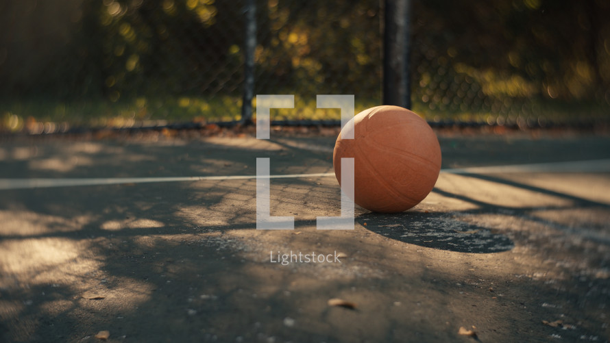 Close up of a basketball on an outdoor basketball court on a sunny day