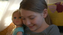 Close up of a cute young girl holding a doll