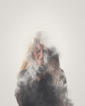 silhouette of a woman behind smoke 