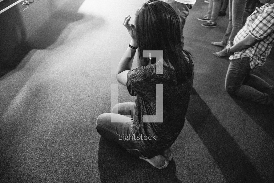 Woman kneeling down crying and praying